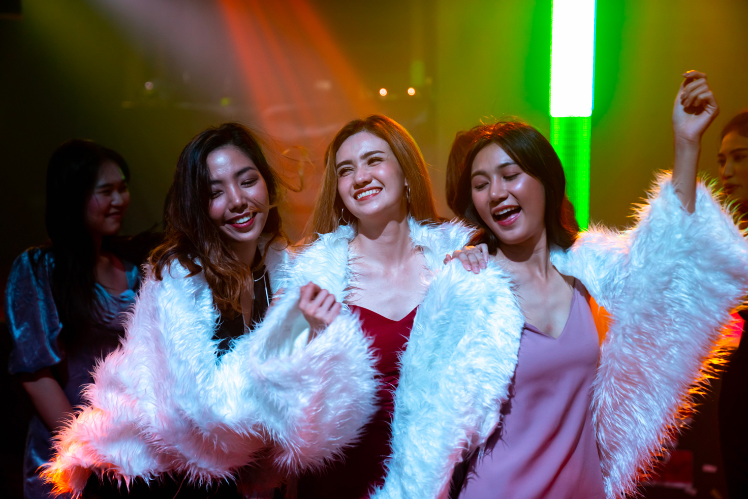 Trois femmes souriantes dansent ensemble lors d'une soirée. - Article de blog Eventdrive