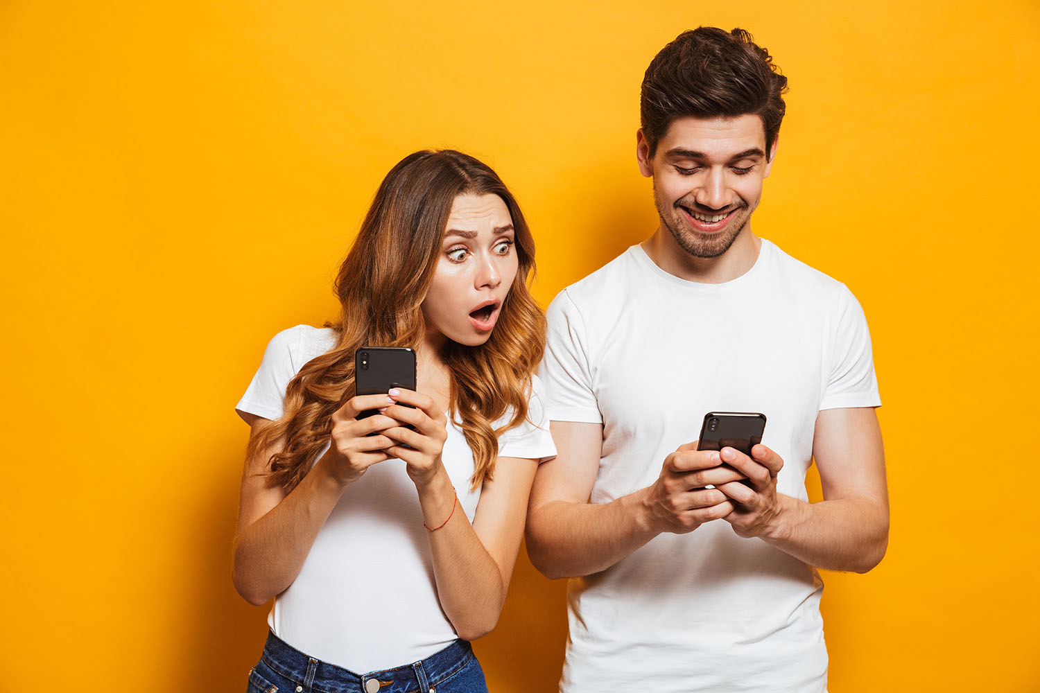 Une femme et un homme regardent leur téléphone portable. - Article de blog Eventdrive