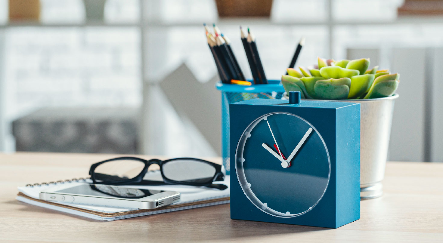 L'image montre une horloge de couleur bleue posée sur un bureau. - Article de blog Eventdrive