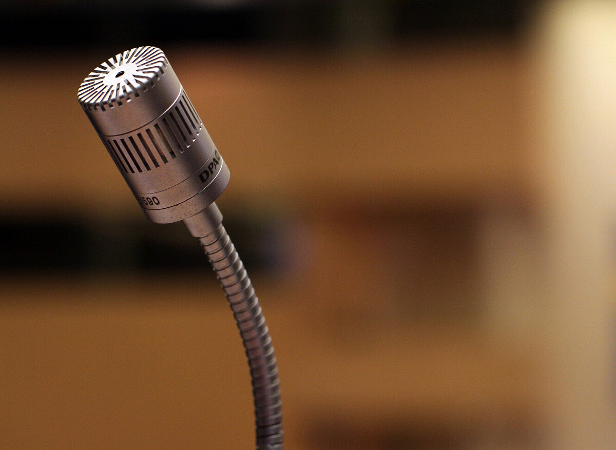 The image shows a close-up of a gooseneck microphone, featuring a metallic body and a grille on top. - Eventdrive Blog Article