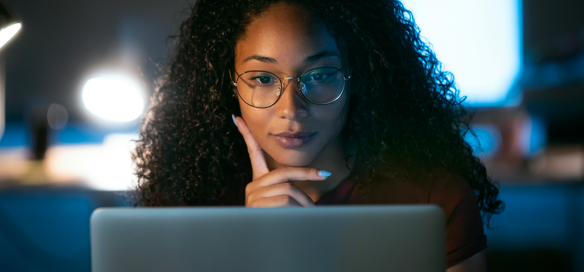 Une femme est en train de réfléchir devant son écran d'ordinateur