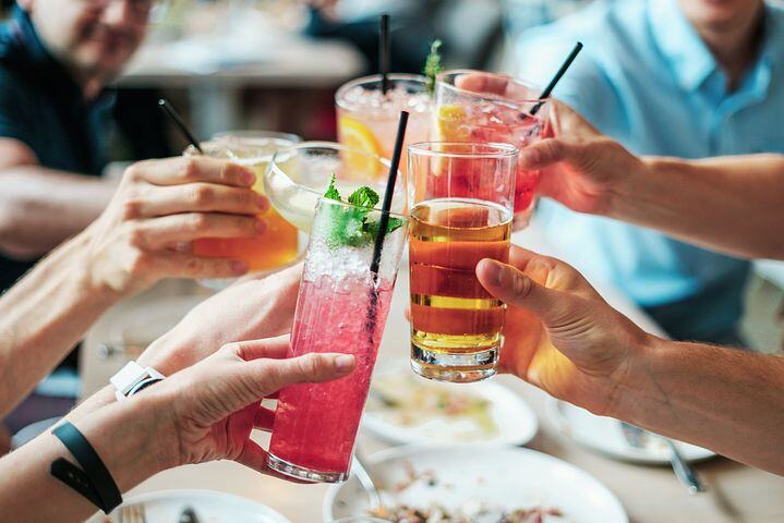 Groupe de personnes trinquant avec des cocktails colorés dans un restaurant. - Article de blog Eventdrive