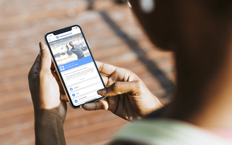 Une personne tient un smartphone, affichant une page d'événement avec des informations telles que l'agenda et les détails de l'événement. - Article de blog Eventdrive