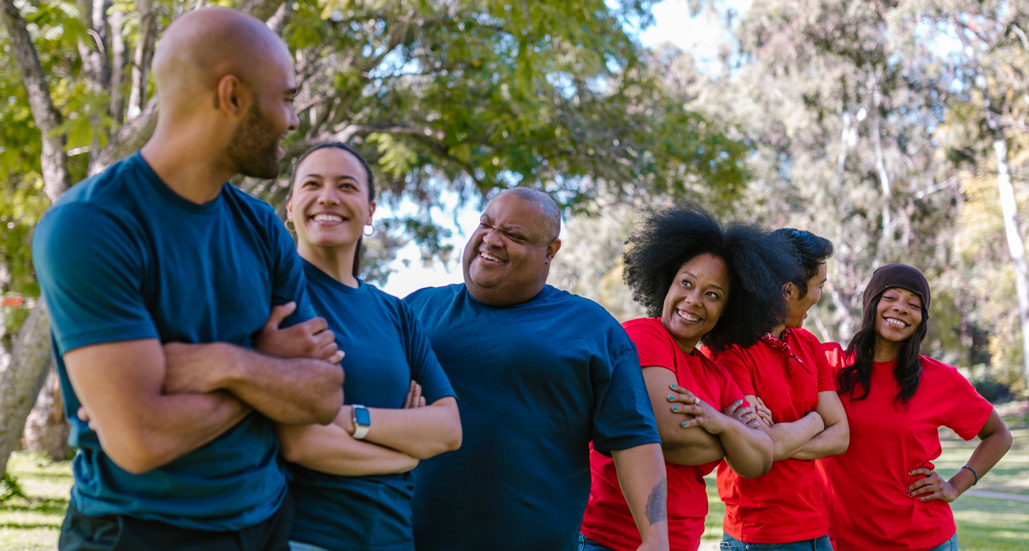 Un groupe de personnes en t-shirts distincts, répartis en deux équipes, l'une en bleu et l'autre en rouge, se prépare à participer à des activités. - Article de blog Eventdrive