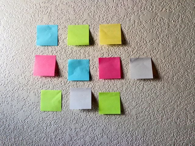 Nine Colorful Post-Its (Yellow, Green, Pink, Blue, and White) Are Stuck to a Textured Wall, Arranged in Three Rows of Three. - Eventdrive Blog Article