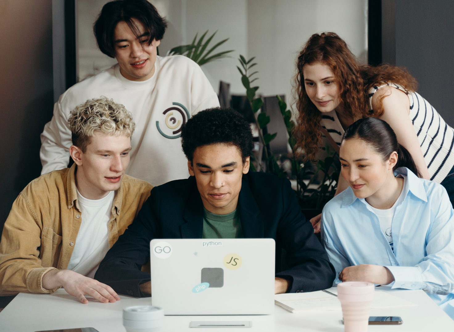 Un groupe de jeunes personnes collaborent autour d'une table, devant un ordinateur portable. - Article de blog Eventdrive